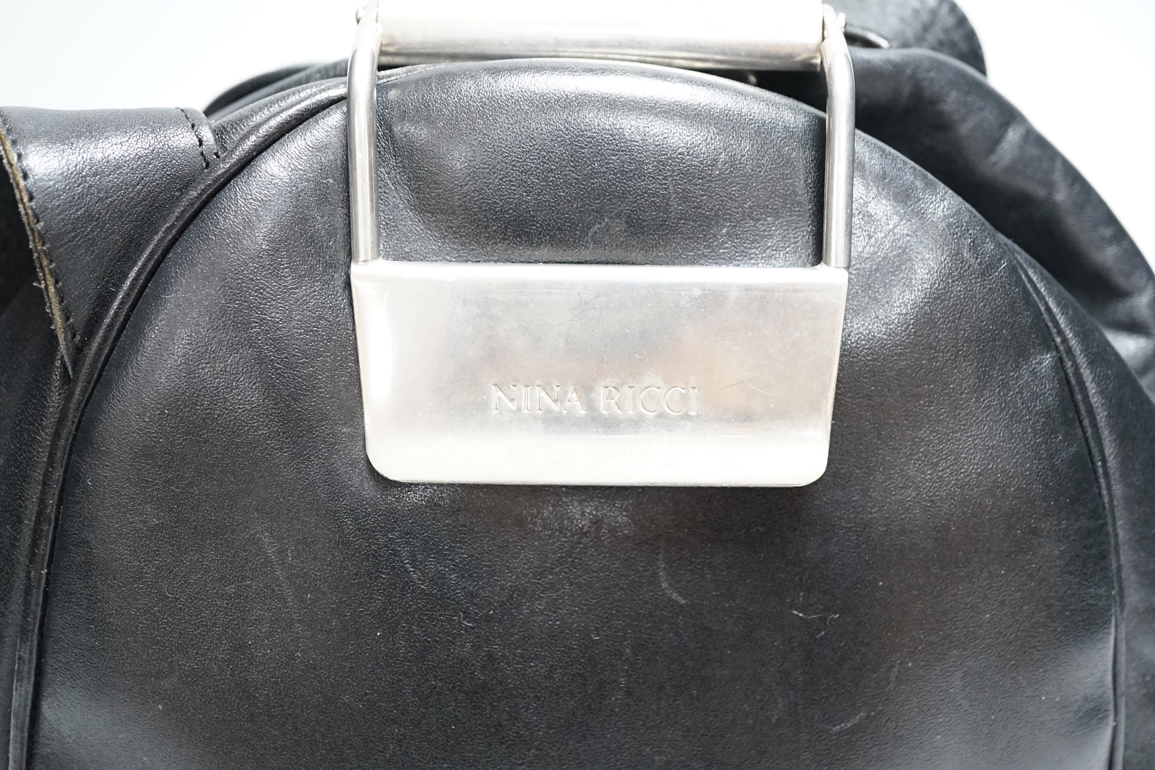 A Nina Ricci black leather shoulder bag with large metal clasp, engraved Nina Ricci, circa 1970's, approx. 23cm high